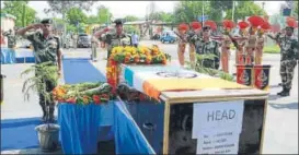  ?? AFP & HT ?? The brother and son of Naib Subedar Paramjit Singh light his funeral pyre in Vein Poin village, about 45km from Amritsar; Border Security Force personnel pay their respects to jawan Prem Sagar during a wreath laying ceremony at Jammu airport, on Tuesday.
