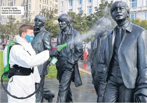  ??  ?? A worker spray cleans the Beatles statue in Liverpool