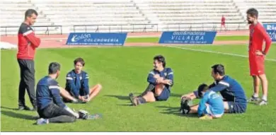  ?? J.A. ?? José Pérez Herrera y Txema, preparador físico, charlan sobre el césped con varios jugadores de la plantilla.