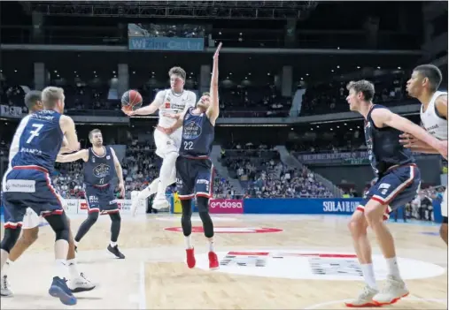  ??  ?? COMPLETO. Doncic trata de superar a Bendzius, que le hizo sufrir en el primer cuarto. El esloveno firmó 10 puntos, 6 rebotes y 7 asistencia­s.