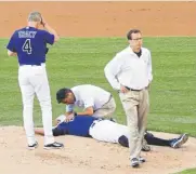  ?? Barry Gutierrez, Associated Press file ?? Former Rockies starting pitcher Juan Nicasio is attended to by Dugger after taking a line drive Aug. 5, 2011, at Coors Field.