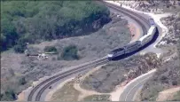  ?? Photo courtesy of KABC ?? A Los Angeles County Fire Department Air Operations helicopter maneuvers in front of a train in order to get it to stop. The speeding train was heading toward a fire that broke out by the tracks.