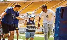  ?? Courtesy Cal football ?? Cal linebacker BJ Jones, right, helps a youngster during the Golden Buddies Football Clinic at Memorial Stadium on July 15.