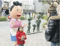  ??  ?? A child poses for a photo with Sazae-san.