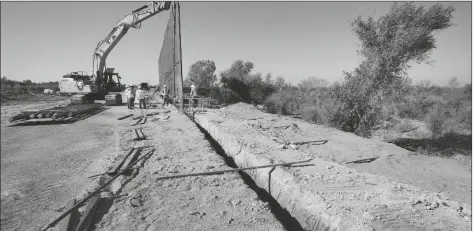  ?? ASSOCIATED PRESS ?? IN THIS SEPT. 10, 2019, FILE PHOTO government contractor­s erect a section of Pentagon-funded border wall along the Colorado River in Yuma The federal Bureau of Land Management said on Tuesday that it’s transferre­d over 65 acres of public land in Arizona and New Mexico to the Army for constructi­on of border wall infrastruc­ture.