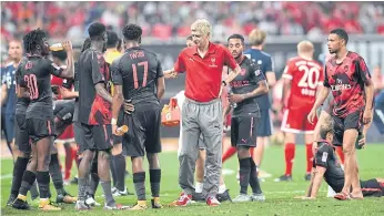  ??  ?? Arsenal coach Arsene Wenger, centre, speaks to his players in Shanghai.