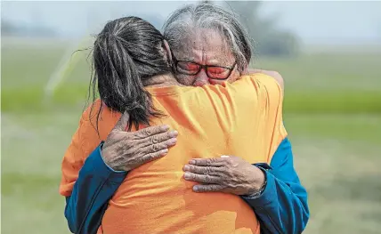  ?? LIAM RICHARDS
THE CANADIAN PRESS ?? Elder and residentia­l school survivor Jenny Spyglass, right, hugs Karen Whitecalf, project lead for the school ground search in Delmas, Sask., embrace Saturday at the site where ground-penetratin­g radar is being used to search for unmarked graves.