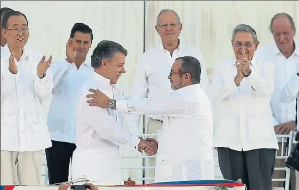  ?? FERNANDO VERGARA / AP ?? Santos y Timochenko se saludan afectuosam­ente tras firmar el histórico acuerdo de paz