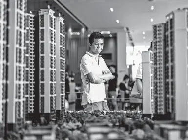  ?? AN DONG / FOR CHINA DAILY ?? A customer checks building models at the sales office of a housing project developed by China Vanke Co in Dongguan, Guangdongp­rovince.