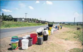  ?? Photos: Delwyn Verasamy ?? Back to blue: Wheels lighten the load while carting water from tankers in Hammanskra­al (left). Residents of Qwa Qwa place empty buckets (right) next to the main road as they wait for the water trucks to arrive.