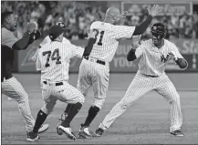  ?? JULIE JACOBSON/AP PHOTO ?? Miguel Andujar of the Yankees, right, is mobbed by teammates after hitting a single in the ninth inning to in a 7-6 win over the Indians on Friday night at New York.