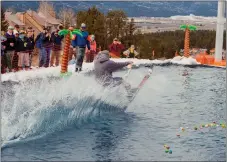  ?? MIKE HAWKINS/For Angel Fire Resort ?? An elegant wake, but will he make it all the way across the pond? The Angel Fire Resort Pond Skim was a fan favorite on closing day Sunday (March 24). Wacky costumes and acrobatic jump-outs added points to a competitor’s till.