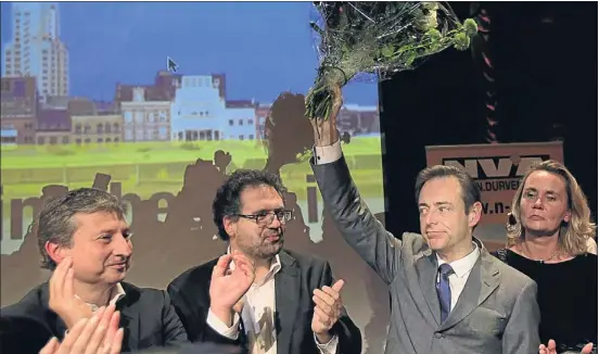  ?? YVES HERMAN / REUTERS ?? Amb deu punts d’avantatge. Bart de Wever (amb el ram de flors) celebrant amb membres del seu partit la victòria sobre l’alcalde actual d’Anvers, el socialista Patrick Janssens, ahir al teatre Zuiderkroo­n d’Anvers