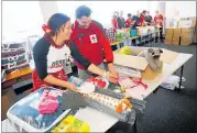  ?? PICTURE / MICHAEL CUNNINGHAM ?? Red Cross Northland community services manager Nancy Kareroa-Yorke and corporate partnershi­ps manager Matthew McCracken assembling one of the Winter Warmer packages.