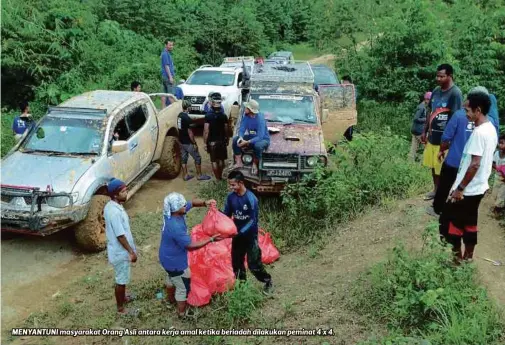  ??  ?? MENYANTUNI masyarakat Orang Asli antara kerja amal ketika beriadah dilakukan peminat 4 x 4.