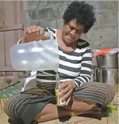  ??  ?? Mrs Vuli pouring the virgin coconut oil into bottles for relatives in Suva.
