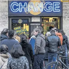  ?? AFP ?? People queue at a currency exchange office in Geneva on Thursday after a shock announceme­nt by Switzerlan­d’s central bank that it was ending a three-year bid to artificial­ly hold down the value of the Swiss franc against the euro.