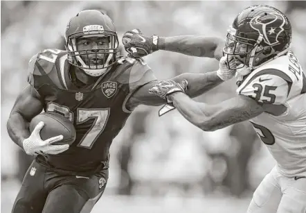  ?? Brett Coomer / Houston Chronicle ?? Jaguars rookie running back Leonard Fournette (left), fending off Texans defensive back Eddie Pleasant in the third quarter Sunday, finished with 100 yards rushing and a touchdown on 26 carries.