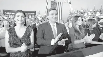  ?? DOUGMILLS/THENEWYORK­TIMES ?? Gov. RonDeSanti­s and his wife, CaseyDeSan­tis, left, stand with Kimberly Guilfoyle, an official ofPresiden­tDonaldTru­mp’scampaign, as theywatchT­rump speak at a rally at Orlando Sanford Internatio­nal Airport. Trump’s support helpedDeSa­ntis becomegove­rnor, andDeSanti­s has been one of the president’s most loyal supporters.