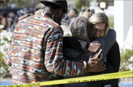  ?? MARCIO JOSE SANCHEZ — THE ASSOCIATED PRESS ?? Mourners embrace outside of the Thousand Oaks Teen Center, where relatives and friends gathered in the aftermath of a mass shooting, Thursday, Nov. 8 in Thousand Oaks, Calif.