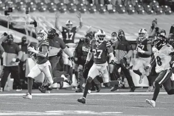  ??  ?? Bills cornerback Taron Johnson, left, runs away from Ravens quarterbac­k Lamar Jackson (8) after intercepti­ng his pass for a touchdown during the second half of Buffalo's 17-3 win Saturday in Orchard Park, N.Y. [AP PHOTO/ADRIAN KRAUS]