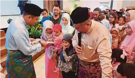  ?? (Foto Faiz Anuar/bh) ?? Mohd Najwan menyampaik­an duit raya kepada kanak-kanak pada Majlis Rumah Terbuka Aidilfitri DUN Kota Anggerik di Shah Alam, semalam.