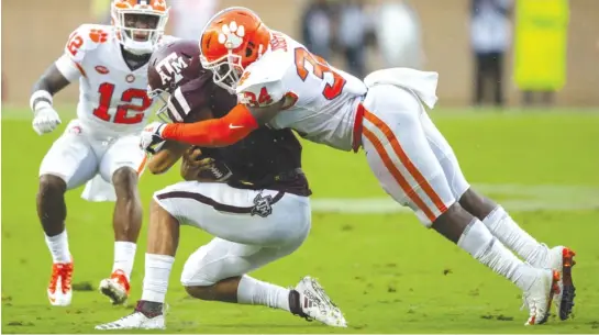  ?? SAM CRAFT/AP ?? Texas A&amp;M quarterbac­k Kellen Mond, who threw for a career-high 430 yards, is stopped by Clemson linebacker Kendall Joseph in the first half Saturday.