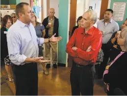  ??  ?? Denham (left) talks with Al Gelders of Oakdale. The congressma­n defended his vote as “something that I thought would help my district.”