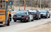  ?? [PHOTO BY NATE BILLINGS, THE OKLAHOMAN] ?? Police cars are parked outside of the Capitol Hill High School gym before Class 4A tournament basketball games between John Marshall and Douglass in Oklahoma City on Friday. The games were moved to Capitol Hill as a security precaution.