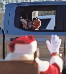  ?? Tyler Sizemore / Hearst Connecticu­t Media ?? In this file photo, Santa waves to passers by during the Christmas car parade at Darien High School in Darien on Dec. 6. Darien's three fire department­s held a holiday drive-thru for cars featuring fire trucks and an appearance by Santa Claus. Donations for Toys for Tots and Person to Person were also collected at the event.