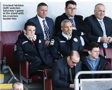  ??  ?? Crocked: McGinn (left) watches Saturday’s game in the stand with his crutches beside him