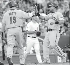  ?? Kansas City Star ?? Cincinnati Reds first baseman Joey Votto, left, high-fives San Francisco Giants outfielder Melky Cabrera as he scores in the first inning in the
MLB all-star game on Tuesday in Kansas City, Mo.