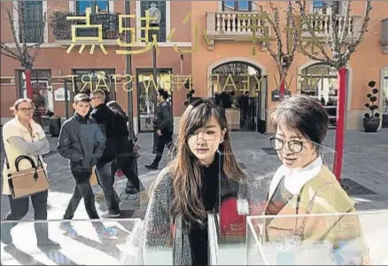  ?? GEMMA MIRALDA ?? Dos turistas chinas miran un escaparate en una tienda de La Roca Village