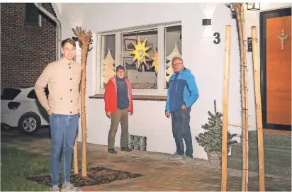  ?? RP-FOTO: RUTH KLAPPROTH ?? Die Organisato­ren der Adventsfen­ster in Beeck, Wolfgang Stieger (Mitte) und Heinz Nix (rechts), besichtige­n bei Daniel Siebel (links) im Zehntweg das geschmückt­e Adventsfen­ster mit der Nummer 3.
