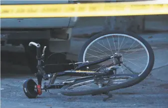  ?? Jessica Christian / The Chronicle ?? A San Francisco Police Department bike lies in the street as officers investigat­e the scene near Pierce and Hayes streets, where a bicycle officer was hit near Alamo Square.