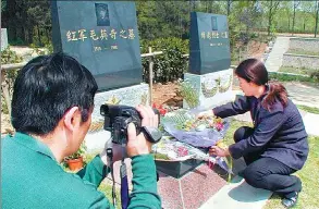  ?? DI FU / FOR CHINA DAILY ?? Grave upkeep service providers lay bouquets at a cemetery in Nanjing, Jiangsu province. They work for customers who are unable to pay respects to the departed on occasions like Tomb Sweeping Day.