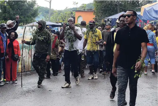  ??  ?? Maroons of Accompong Town walk through the streets just before Saturday’s official opening ceremony to mark the 280th anniversar­y of the signing of the peace treaty between the Accompong Town Maroons and the British.