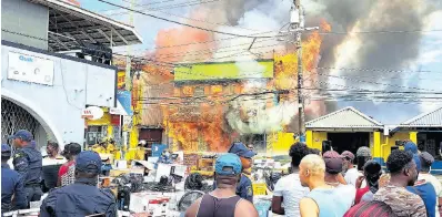  ?? CONTRIBUTE­D ?? Kamals Supermarke­t and Cambio and Portland Jewelers furniture and appliance store being consumed by fire in Port Antonio, Portland, yesterday.