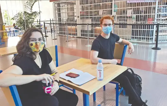  ?? DOUGLAS TODD ?? Capilano University theatre students Melissa Morton and Nicholas Seguin chat in an empty cafeteria. Seguin says the isolation brought about by the pandemic hurts his soul.