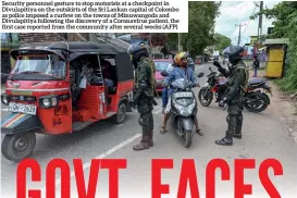  ??  ?? Security personnel gesture to stop motorists at a checkpoint in Divulapiti­ya on the outskirts of the Sri Lankan capital of Colombo as police imposed a curfew on the towns of Minuwangod­a and Divulapiti­ya following the discovery of a Coronaviru­s patient, the first case reported from the community after several weeks (AFP)