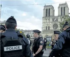  ?? BERTRAND GUAY/GETTY IMAGES ?? French police officers gather outside the Notre-Dame cathedral in Paris on Tuesday after a man with a hammer was shot after attacking an officer.