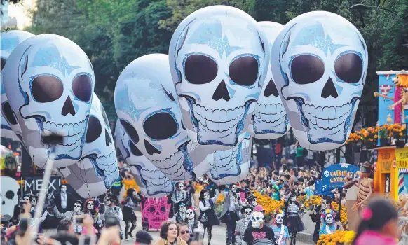  ?? Picture: AFP PHOTO/VICTOR CRUZ ?? People take part in the traditiona­l Day of the Dead parade in Mexico City at the weekend.