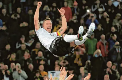  ?? Foto: Ina Fassbender, dpa ?? Hoch soll er leben: Die Kollegen werfen Lukas Podolski in die Luft. Der Nationalsp­ieler genießt den Moment ganz offensicht­lich.
