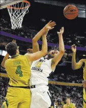  ?? BILL WIPPERT/THE ASSOCIATED PRESS ?? West Virginia’s Nathan Adrian (11) takes it on the chin in a battle for a rebound against Notre Dame’s Matt Ryan (4).