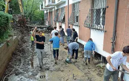  ??  ?? Via di Salviano, la strada che collega ben tre quartieri di Livorno invasa dal fango: volontari a lavoro. Ecco com’è adesso