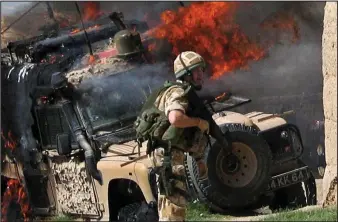  ??  ?? Under fire: A Land Rover burns as British troops are attacked in Helmand in 200