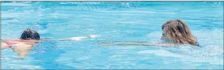  ??  ?? CITY OF YUMA LIFEGUARD ELI MCBRIDE (RIGHT) swims out to fellow lifeguard Briana Zendejas in the deep end at Valley Aquatic Center, after Zendejas suffered a neck injury while diving in, during a mock exercise. City of Yuma Fire Department Capt. Tony...