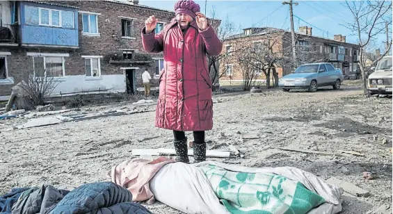  ?? ?? Horror. En la ciudad oriental de Avdiivka, una mujer llora, impotente, ante los cuerpos envueltos en frazadas, de víctimas de los bombardeos rusos.