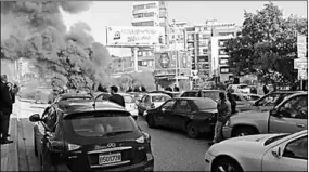  ??  ?? Cars stuck in a traffic jam as antigovern­ment protesters block a road with burning tyres during a demonstrat­ion in Beirut. (Photo:Al Jazeera)
