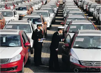  ?? CHINATOPIX VIA AP ?? Customs officials inspect cars being loaded for export at a port in Qingdao, China. The launch of a U.S. trade investigat­ion into whether the imports of autos and auto parts threaten national security is seen as a possible attempt for the U.S. to gain...